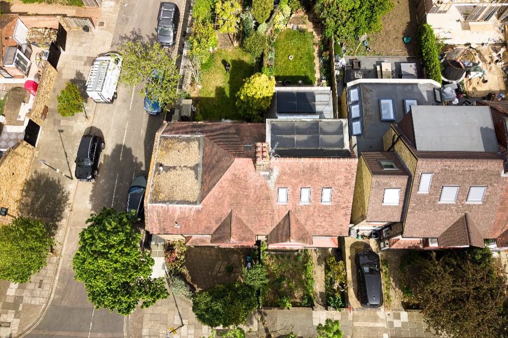 Top-down aerial view of London residential rooftops, gardens and street